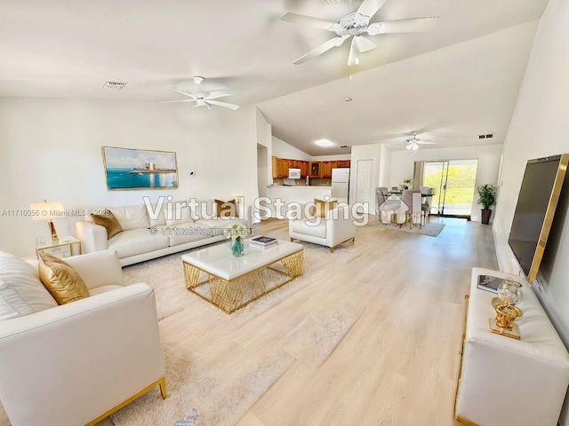 living room with vaulted ceiling and light hardwood / wood-style flooring