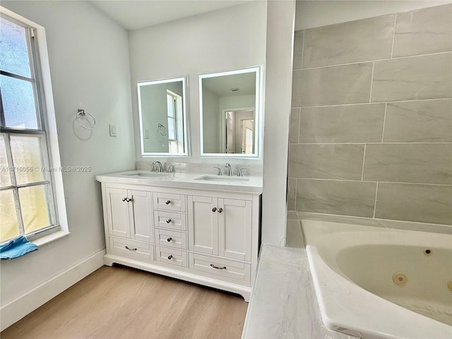 bathroom with a tub, hardwood / wood-style floors, and vanity