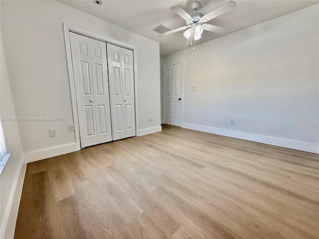 unfurnished bedroom featuring a closet, light hardwood / wood-style floors, and ceiling fan