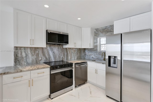 kitchen featuring white cabinets, decorative backsplash, sink, and appliances with stainless steel finishes