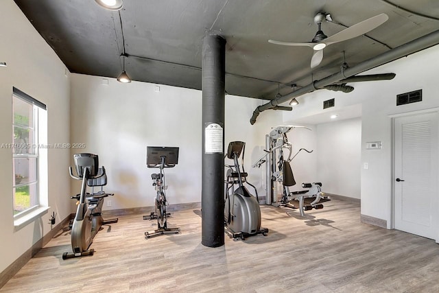 exercise area with ceiling fan, light hardwood / wood-style floors, and a healthy amount of sunlight