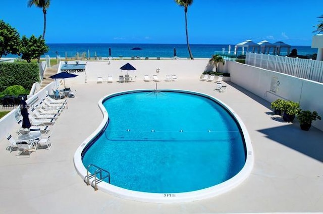 view of pool featuring a patio area and a water view