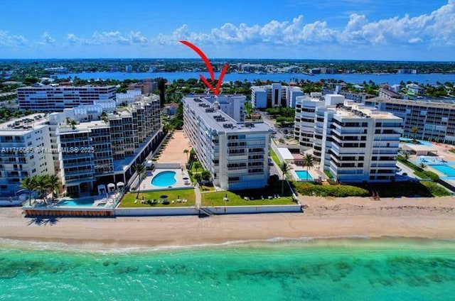 drone / aerial view featuring a water view and a beach view