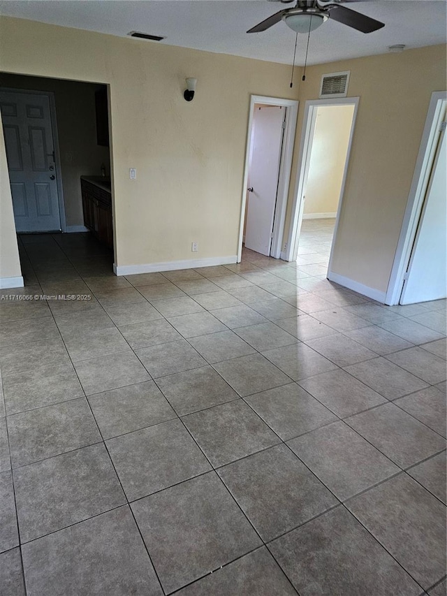 tiled spare room with ceiling fan