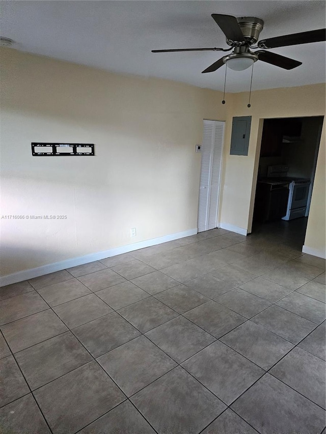 tiled empty room with electric panel and ceiling fan