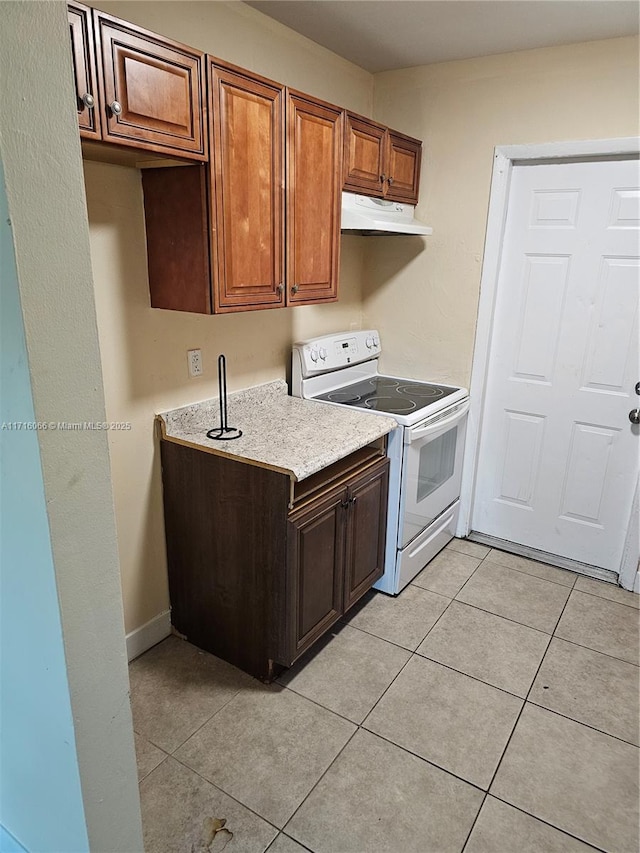 kitchen featuring light tile patterned floors and white electric stove