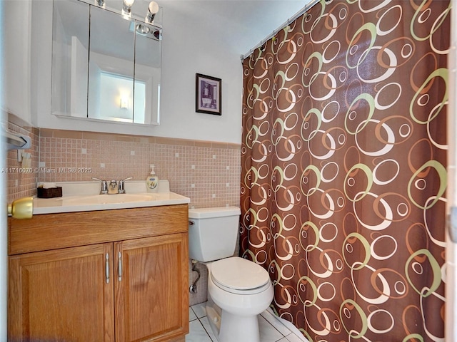 bathroom featuring tile patterned floors, vanity, tile walls, and toilet