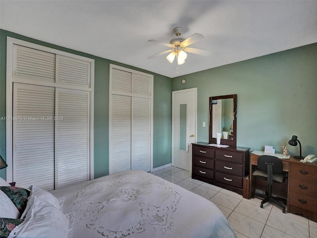 tiled bedroom featuring ceiling fan and two closets