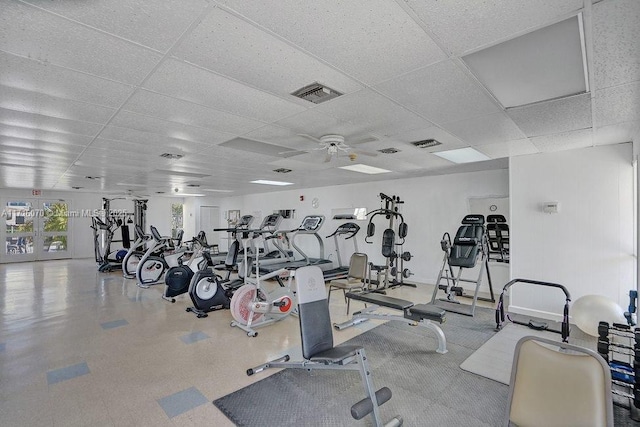 exercise room with a paneled ceiling and ceiling fan