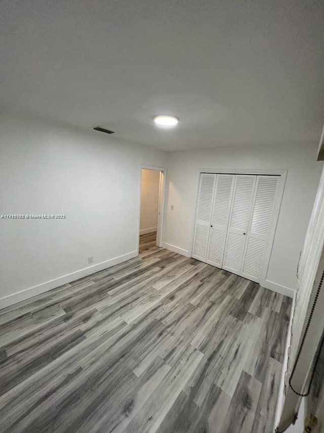 unfurnished bedroom featuring a closet and hardwood / wood-style flooring