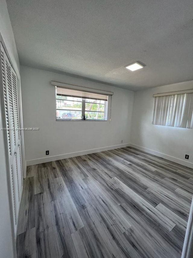 interior space with a textured ceiling, a closet, and hardwood / wood-style floors