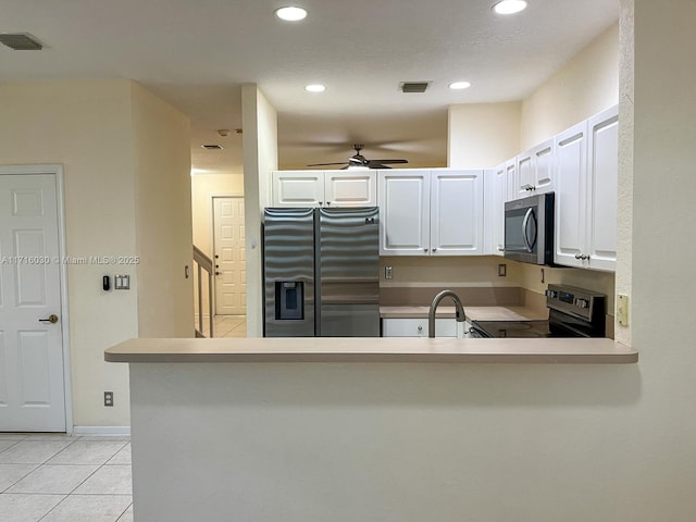 kitchen featuring kitchen peninsula, white cabinets, stainless steel appliances, and light tile patterned floors