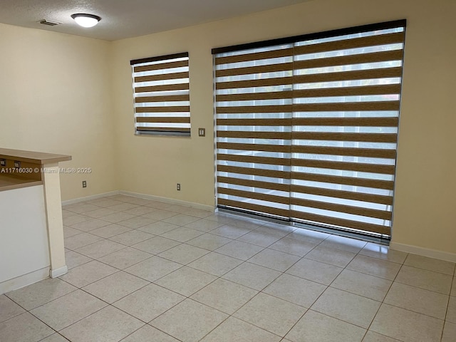 unfurnished dining area with light tile patterned floors and a textured ceiling