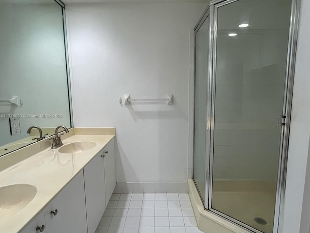 bathroom with tile patterned flooring, vanity, and walk in shower