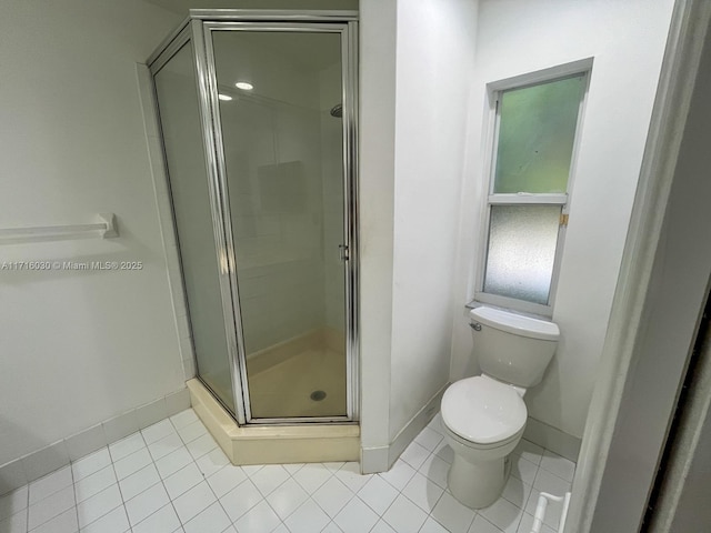 bathroom featuring tile patterned flooring, toilet, and walk in shower