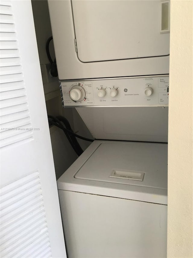 clothes washing area with stacked washer and clothes dryer