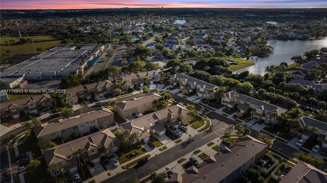 aerial view at dusk featuring a water view