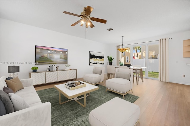 living room with ceiling fan and wood-type flooring