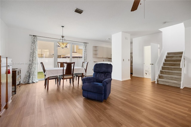 sitting room with ceiling fan with notable chandelier and hardwood / wood-style flooring