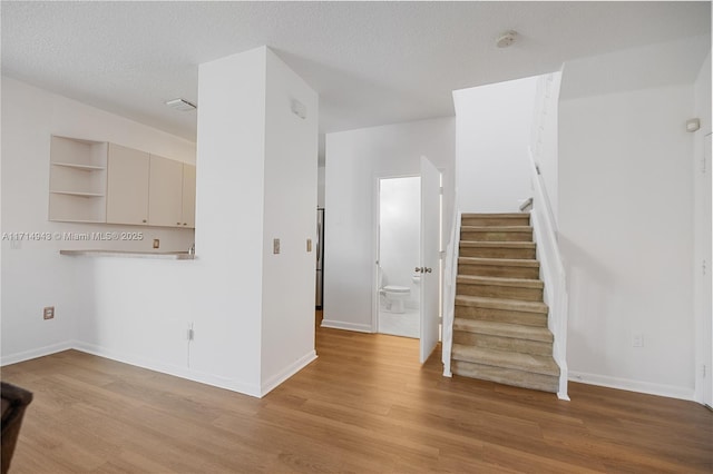 interior space featuring a textured ceiling and hardwood / wood-style floors