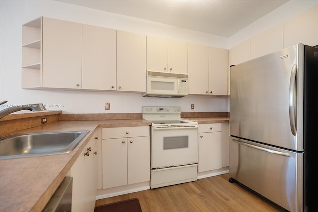 kitchen featuring sink, white appliances, and light hardwood / wood-style floors