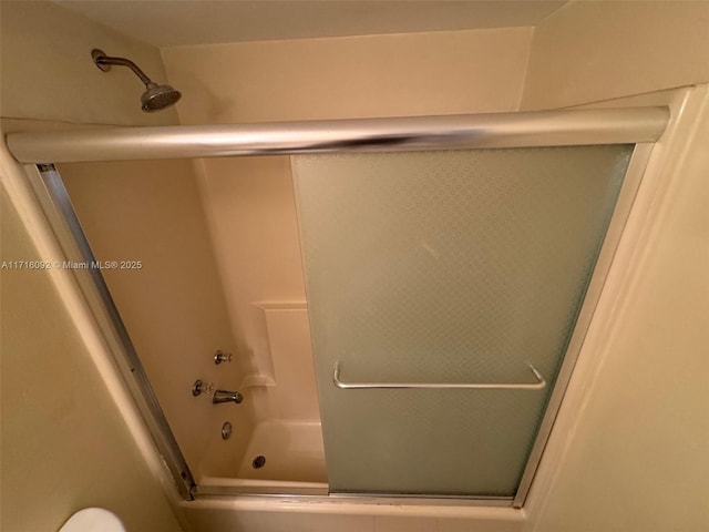 bathroom featuring bath / shower combo with glass door