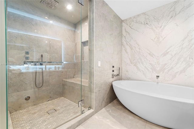 bathroom featuring plus walk in shower and tile walls