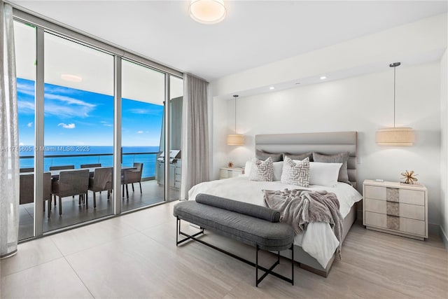 bedroom featuring a water view, floor to ceiling windows, and access to outside