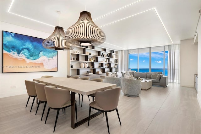 dining room with a water view, expansive windows, and built in shelves