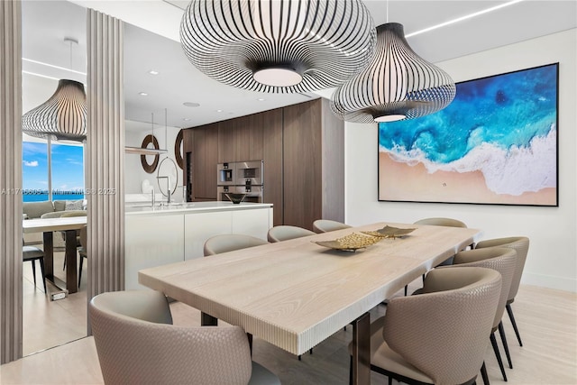 dining room featuring a water view and wooden walls