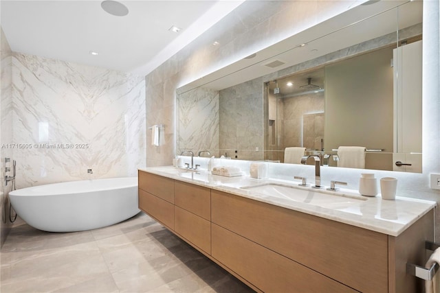 bathroom with tile walls, vanity, and independent shower and bath