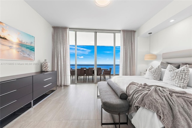 bedroom with a water view, floor to ceiling windows, and access to outside