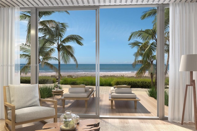 exterior space with expansive windows, a water view, and a view of the beach