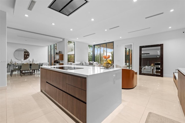 kitchen featuring black electric stovetop, light tile patterned floors, and a spacious island