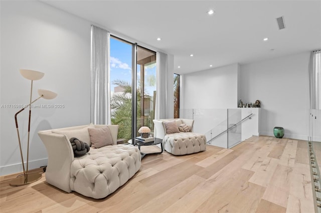 sitting room featuring light hardwood / wood-style floors and a wall of windows