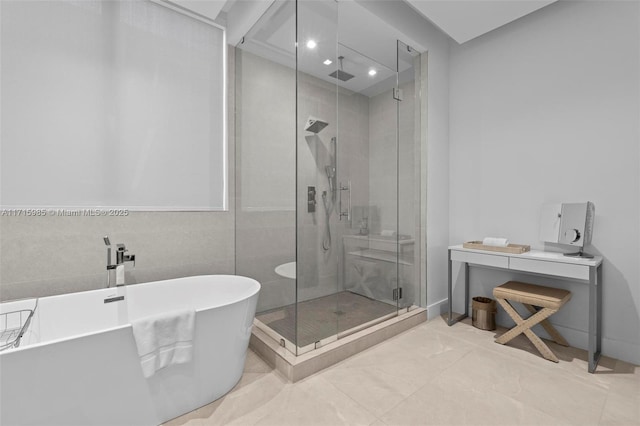 bathroom with shower with separate bathtub and tile walls