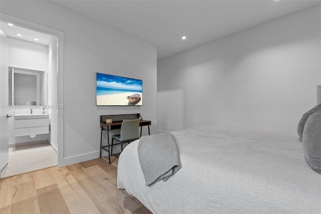 bedroom featuring light hardwood / wood-style flooring and ensuite bath