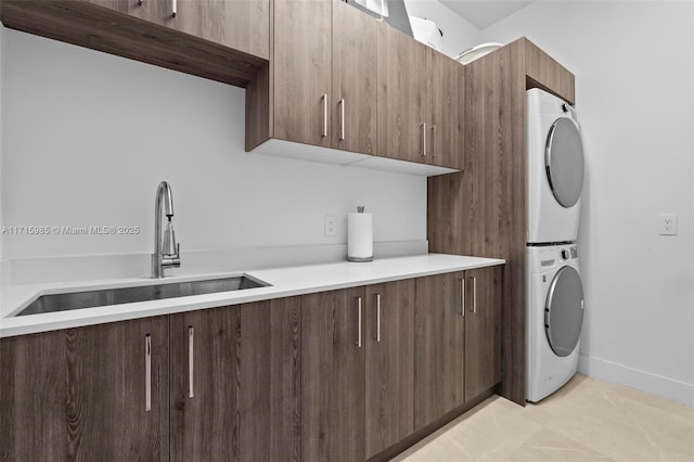 washroom with cabinets, light tile patterned floors, stacked washer and clothes dryer, and sink