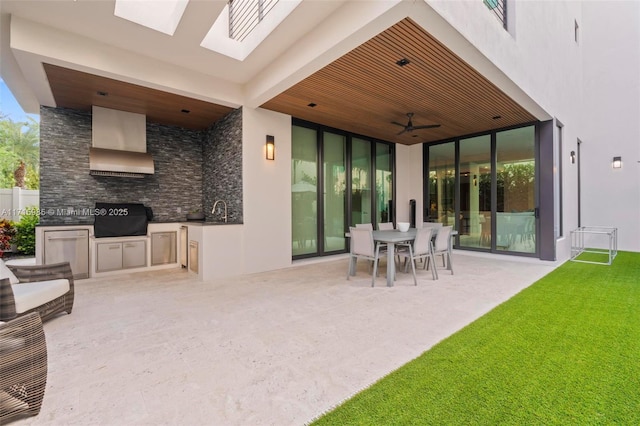 exterior space featuring an outdoor kitchen, area for grilling, and ceiling fan