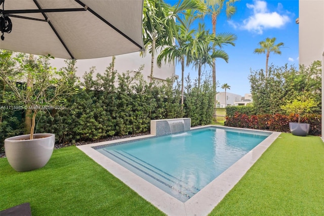 view of pool featuring pool water feature and a lawn