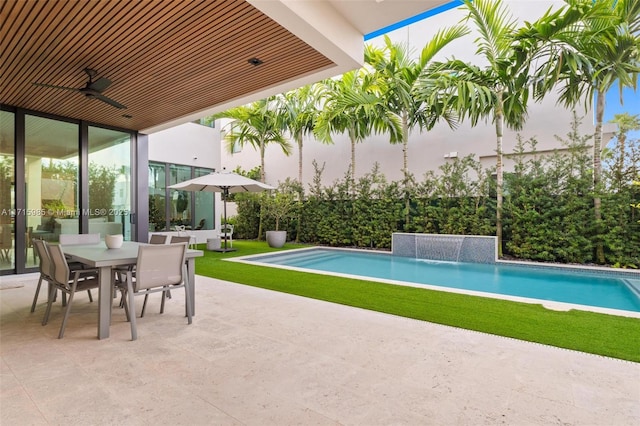 view of swimming pool featuring pool water feature, ceiling fan, and a patio