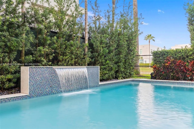 view of swimming pool with pool water feature