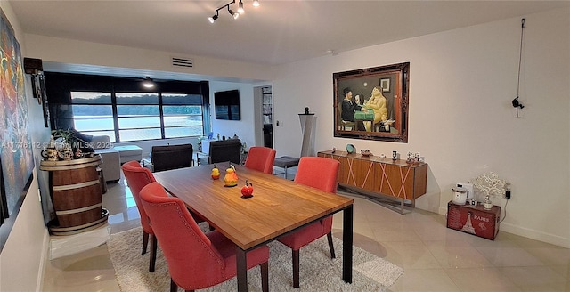 tiled dining area featuring rail lighting