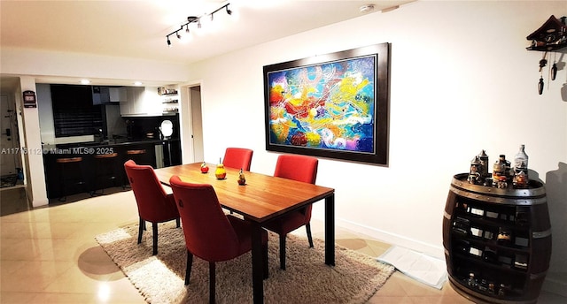 dining space with light tile patterned floors and track lighting