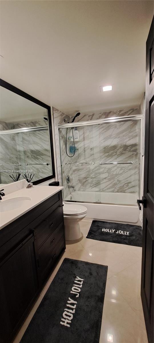 full bathroom with tile patterned flooring, vanity, toilet, and bath / shower combo with glass door