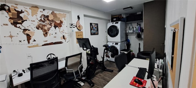 exercise room featuring dark hardwood / wood-style flooring and stacked washer and dryer