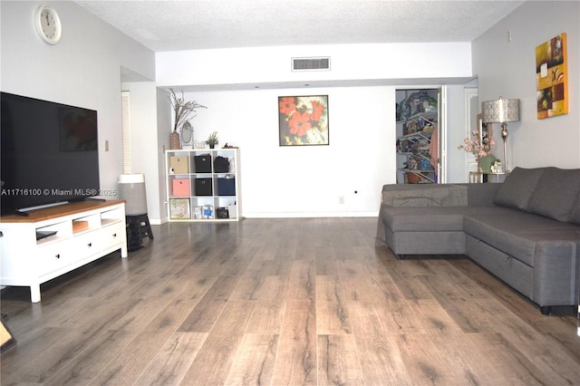 living room with hardwood / wood-style flooring and a textured ceiling