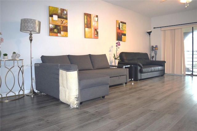 living room featuring ceiling fan and dark hardwood / wood-style floors