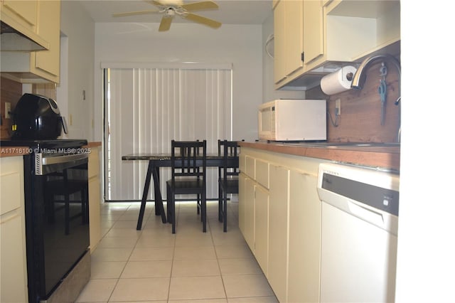 kitchen with cream cabinetry, ceiling fan, light tile patterned flooring, and white appliances