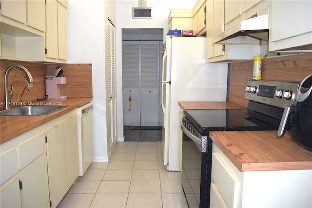 kitchen featuring sink, electric stove, cream cabinets, light tile patterned floors, and dishwasher